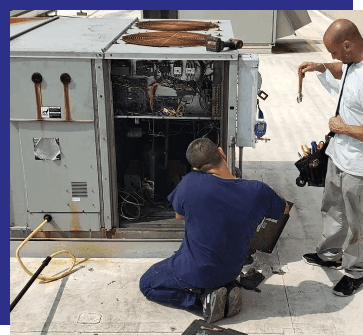 Two men working on an air conditioner unit.